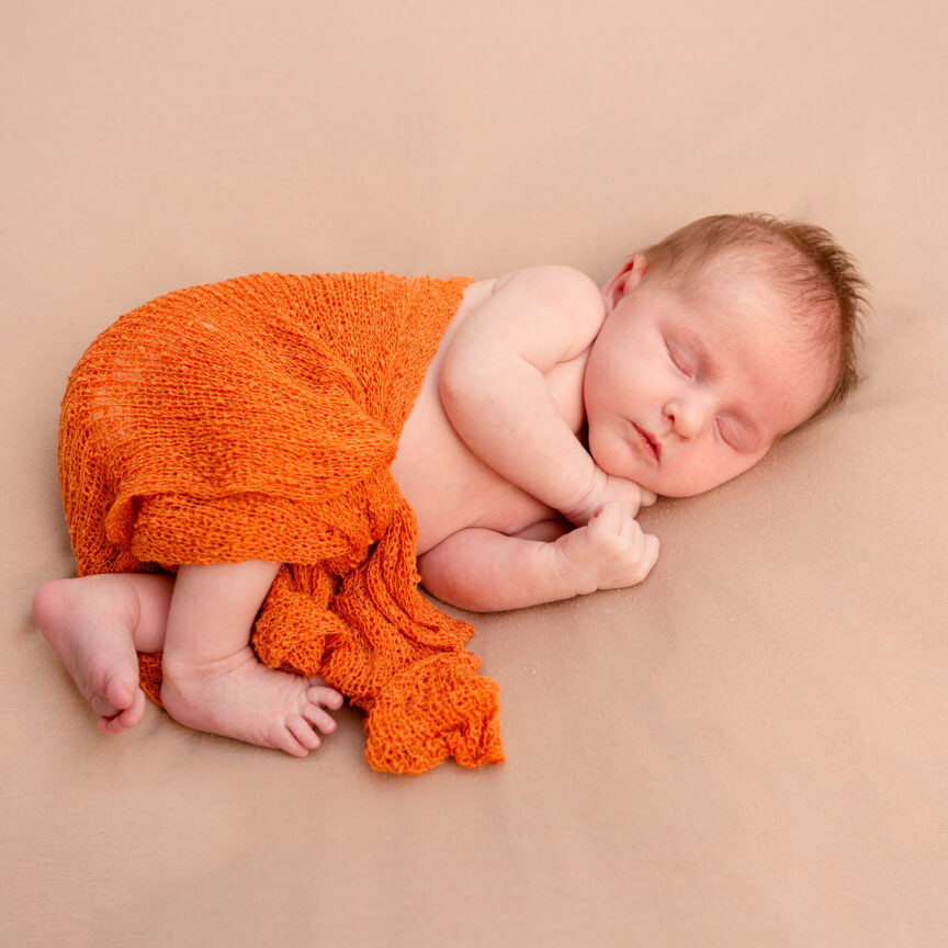 Baby asleep on beige blanket in orange wrap - Newborn Photography - Walsall Wolverhampton and West Midlands - Jo Buckley Photography