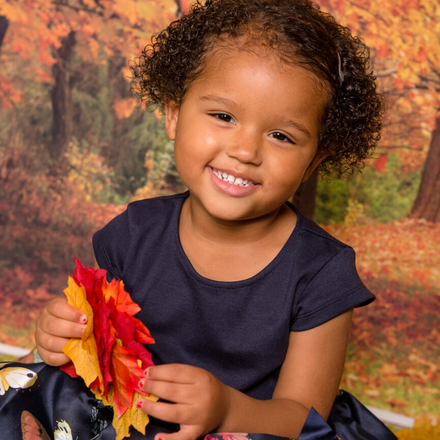 Child smiling to camera in autumn photo set - Nursery Playgroup Photography - Walsall Wolverhampton and West Midlands - Jo Buckley Photography