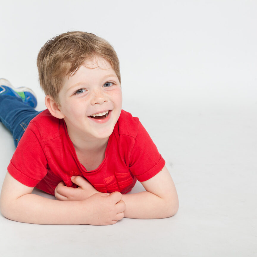 Child smiling at camera laying on tummy - Nursery Playgroup Photography - Walsall Wolverhampton and West Midlands - Jo Buckley Photography